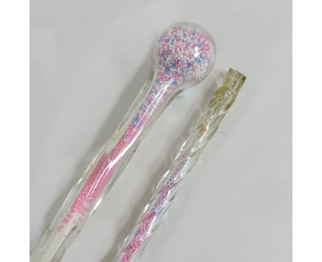 A glass walking stick, together with another