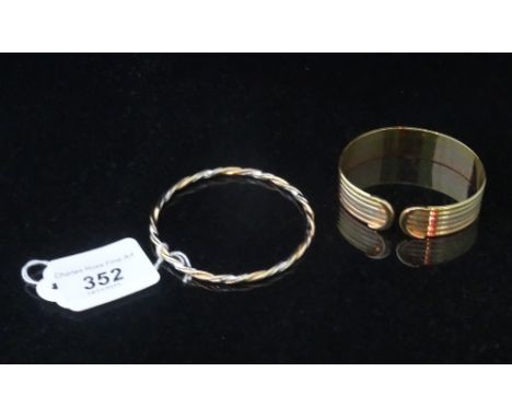 A lady's 18 carat gold bangle, having open ends and linear design, together with a lady's 9 carat gold rope twist bangle. Con