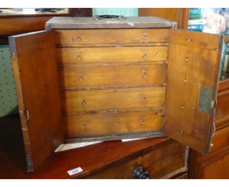 An early 19th century watchmakers tool cabinet and contents, having five graduated doors behind twin cupboard doors.  This lo