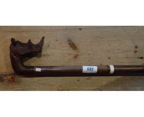 A hardwood walking stick, handmade in Knysna, South Africa, having carved rhinoceros head handle, 95cm. 