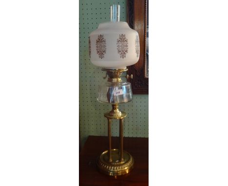 A Victorian lamp, the opaque glass shade over faceted clear glass reservoir on brass four column circular base, 72cm.