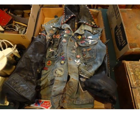 A leather and denim biker's jacket, having a large quantity of enamel and other badges, many of motorcycle interest.