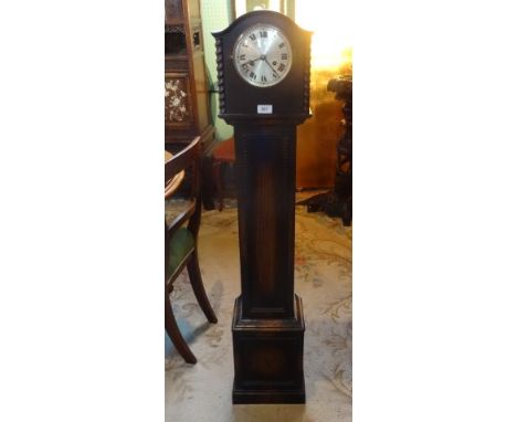 An early 20th century oak cased granddaughter clock, champagne dial bearing Roman numerals flanked by rope twist columns, 130