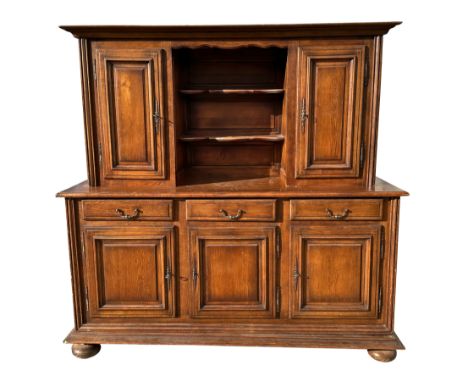 A continental dark wood dresser or buffet, the superstructure with two cupboards above three frieze drawers and cupboards bel