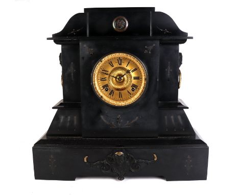 A Victorian black slate mantle clock of architectural form with applied female mask decoration, the gilt dial with Roman nume