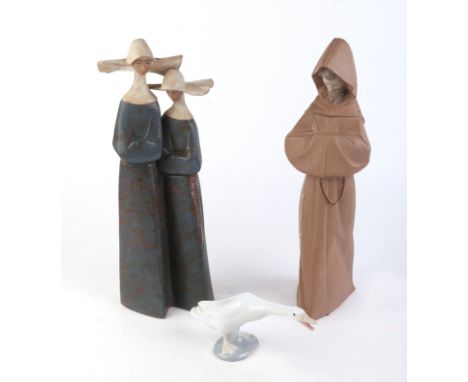 A Lladro group depicting two nuns, 31cms high; together with a Lladro figure of a monk, 34cms high; and a Lladro figure of a 