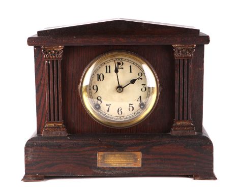 An Edwardian architectural oak mantle clock, having a white dial with arabic numerals fitted a eight day movement, striking o