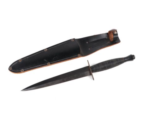 A Commando Knife by A. Wright in its leather scabbard. Marked to the crosspiece: A. WRIGHT & SON. SHEFFIELD. ENGLAND. Blade l