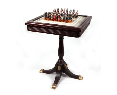 A French Empire style occasional table, the top inset with a chessboard, with two frieze drawers containing chess pieces, on 