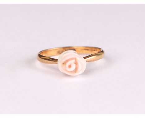 A yellow metal dress ring set with a carved coral flower, approx UK size K, 1.1g.