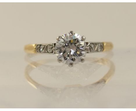 An 18ct solitaire diamond ring of approximately 0.60cts the main diamond is set in an eight claw crown setting with two eight