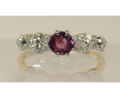 An 18ct diamond and pink gem stone ring set with four old cut diamonds to an approximate diamond total of 0.50cts, with a cen