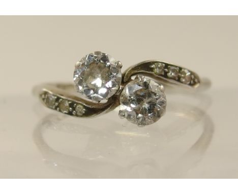 An 18ct twin stone diamond ring with further diamonds to the shoulders, diamond total approx 0.70cts. Finger size Q.