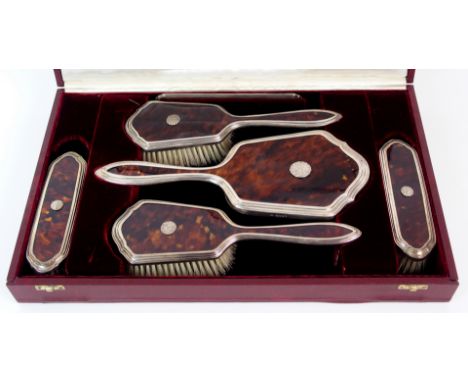 A six piece silver and tortoiseshell dressing table set by Christopher Davison, London 1922, comprising two pairs of brushes,