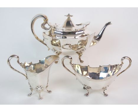 A three piece silver tea service by Lawson & Company, Glasgow 1912, of oval shape, the faceted body with scalloped rim and lo
