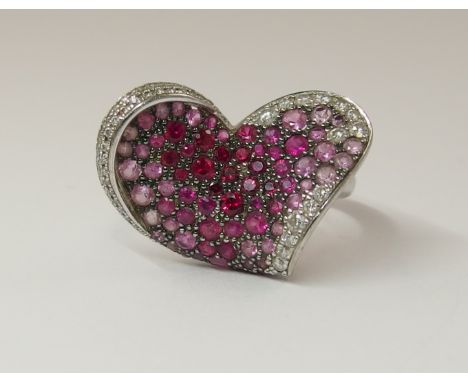 An 18ct white gold Chopard ring with stylized heart motif set with rubies to an approximate weight of 0.55ct, pink sapphires 