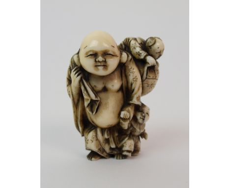A Japanese ivory netsuke of a man carrying a sack with children on his back and his side, 4cm high
