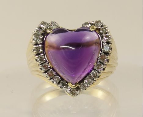 A 14ct yellow gold ring  by American maker Potkel, set with a heart shaped cabouchon amethyst, surrounded with brilliant cut 