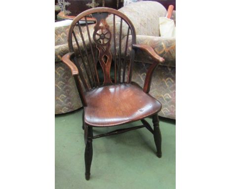 Circa 1860 an elm and oak hoop back Windsor armchair, the stick back with central wheel splat over a dished seat on turned le