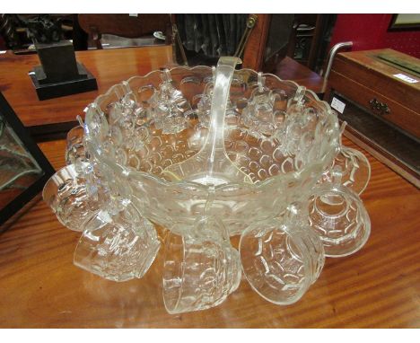 A large glass punch bowl with twelve matching cups and plastic ladle 