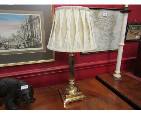 A brass effect table lamp with Corinthian column on square base with a cream silk pleated thread shade, 58cm total height