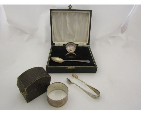 A silver Christening set consisting of egg cup and spoon, a silver napkin ring and a pair of sugar nips (4) 