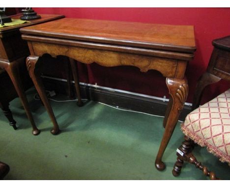 In the manner of "Maple &amp; Co", a George II style crossbanded figured walnut card table the hinged baize revolving top ove