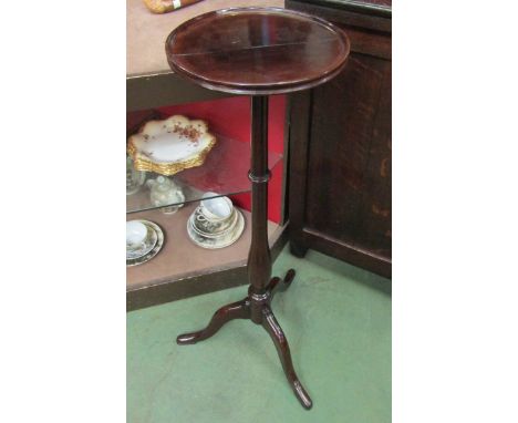 A George III style mahogany candle stand the dished circular top on a turned column and tripod base, split top, 87cm tall    