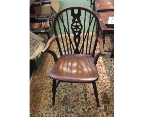 Circa 1860 an elm and oak hoop back Windsor armchair, the stick back with central wheel splat over a dished seat on turned le