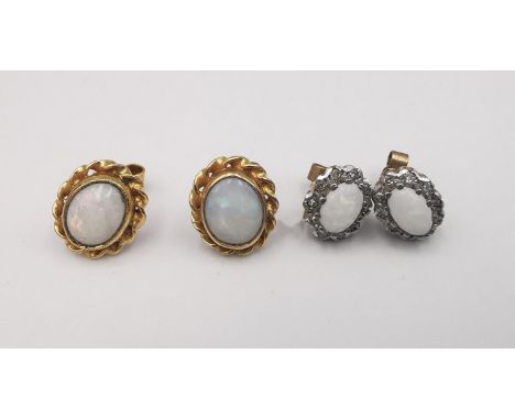 Two pairs of 9ct yellow gold opal stud earrings, one pair with oval opal cabochons in a rope twist border, the two set with a
