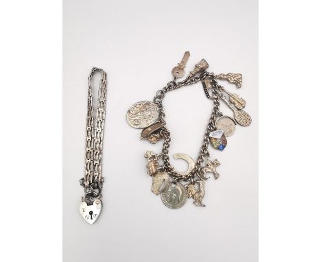 Two silver charm bracelets. One with a bar gate link chain and heart padlock clasp with safety chain. The other curb link bra