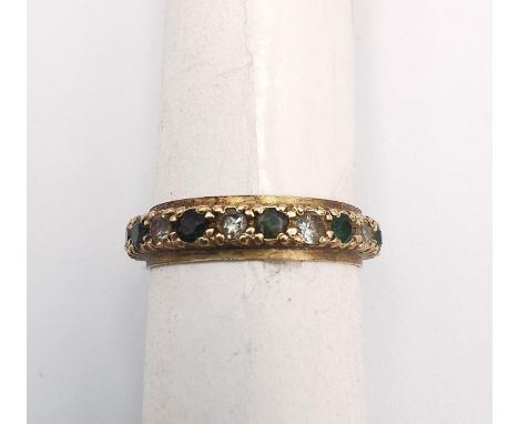 A 9ct yellow gold full eternity ring set with cubic zirconia and green paste stones. Stamped 9ct. Ring Size K. Gross weight 2