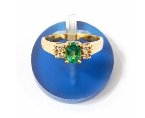 Emerald and diamond ring set central oval cut emerald flanked by two pairs of small diamonds  Live Bidding: If you would like