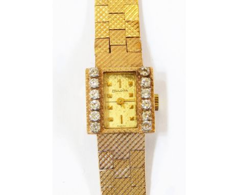 Lady's Bulova gold coloured metal and diamond set wristwatch having rectangular dial, set two rows of six diamonds, button wi