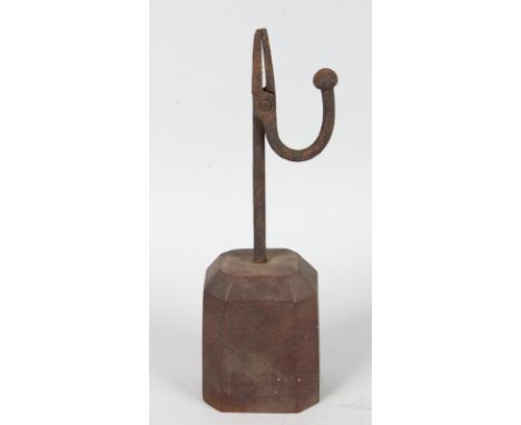 A WROUGHT IRON TAPERING STICK on a wooden base. 9.5ins (24cms) high.