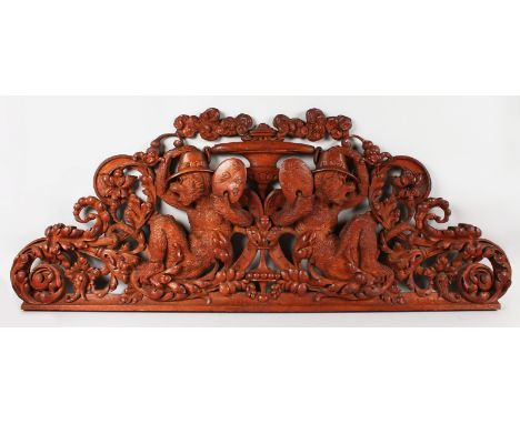 A SUPERB BLACK FOREST CARVED AND PIERCED BRACKET. 48ins long, 20ins high, carved with two monkeys carrying paint pallets with