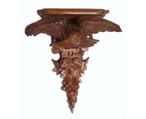 A BLACK FOREST CARVED OAK EAGLE WALL BRACKET. 17ins long.