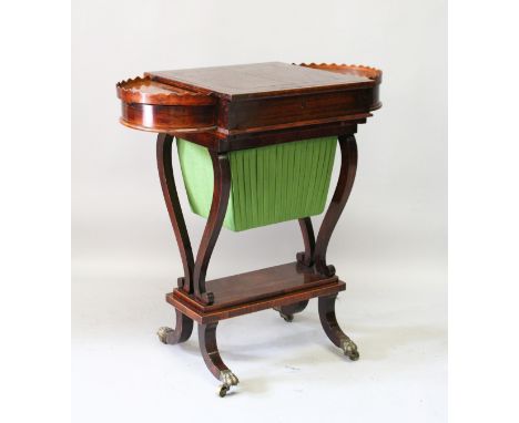 A REGENCY MAHOGANY BACKGAMMON TABLE with writing surface on a ratchet backgammon board below, shaped ends with curving suppor