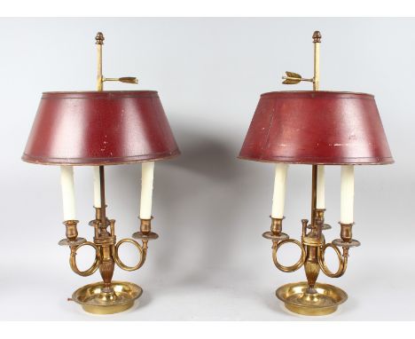 A GOOD PAIR OF FRENCH BRASS THREE LIGHT LAMPS, with tin shades, the curving arms with candle sconces, supported on a circular