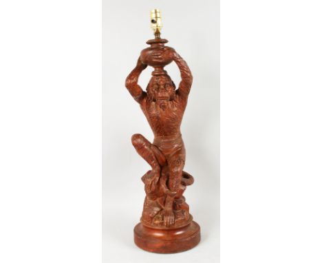 A GOOD BLACK FOREST CARVED WOOD MONKEY LAMP on a circular base. 23ins high.