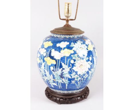 A LARGE CHINESE PORCELAIN GINGER JAR decorated with poppies and other flowers, 11ins high, on a wooden stand converted to a l