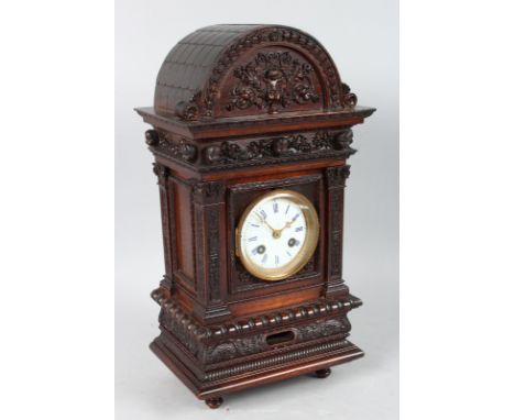 A 19th CENTURY CONTINENTAL CARVED OAK CASED MANTLE CLOCK  carved with cupids, garlands etc. with eight day movement, striking