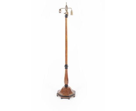A walnut veneer standard lamp, the faceted stem on domed octagonal base, ebony knops and ball feet, with brass three light fi