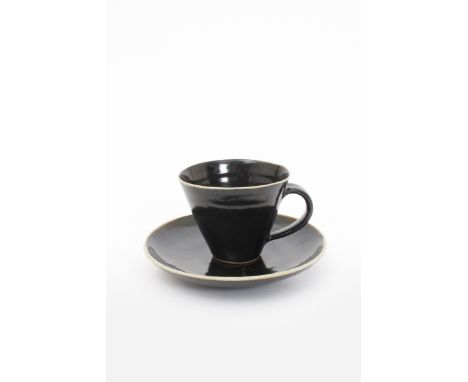 ‡ Dame Lucie Rie D.B.E (1902-1995) and Hans Coper (1920-1981) a porcelain cup and saucer, covered in a deep, rich black glaze