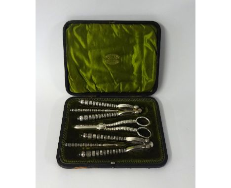 An Edwardian silver plated cased 5 piece nutcracker and grape scissor set in original fitted case, marked Aitkinson.