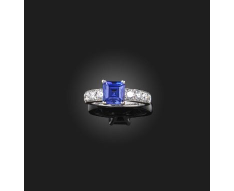 A tanzanite and diamond ring, claw-set with a step-cut tanzanite, to shoulders set with brilliant-cut diamonds, mounted in wh