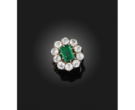 An emerald and diamond ring, 19th century, of cluster design, claw-set with a step-cut emerald weighing approximately 2.10 ca