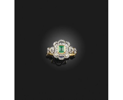 An emerald and diamond ring, early 20th century, of cluster design, set with a step-cut emerald within a floral border set wi