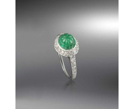 Cartier, a rare Art Deco emerald and diamond ring, 1920s, designed in the 'Tutti Frutti' style, set with a carved emerald, to