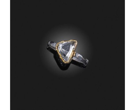 A diamond solitaire ring, the rose-cut diamond in a gold collet setting on a textured silver band, size K 1/2